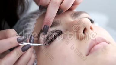 一位睫毛艺术家正在完成<strong>眼睫毛</strong>叠层的程序